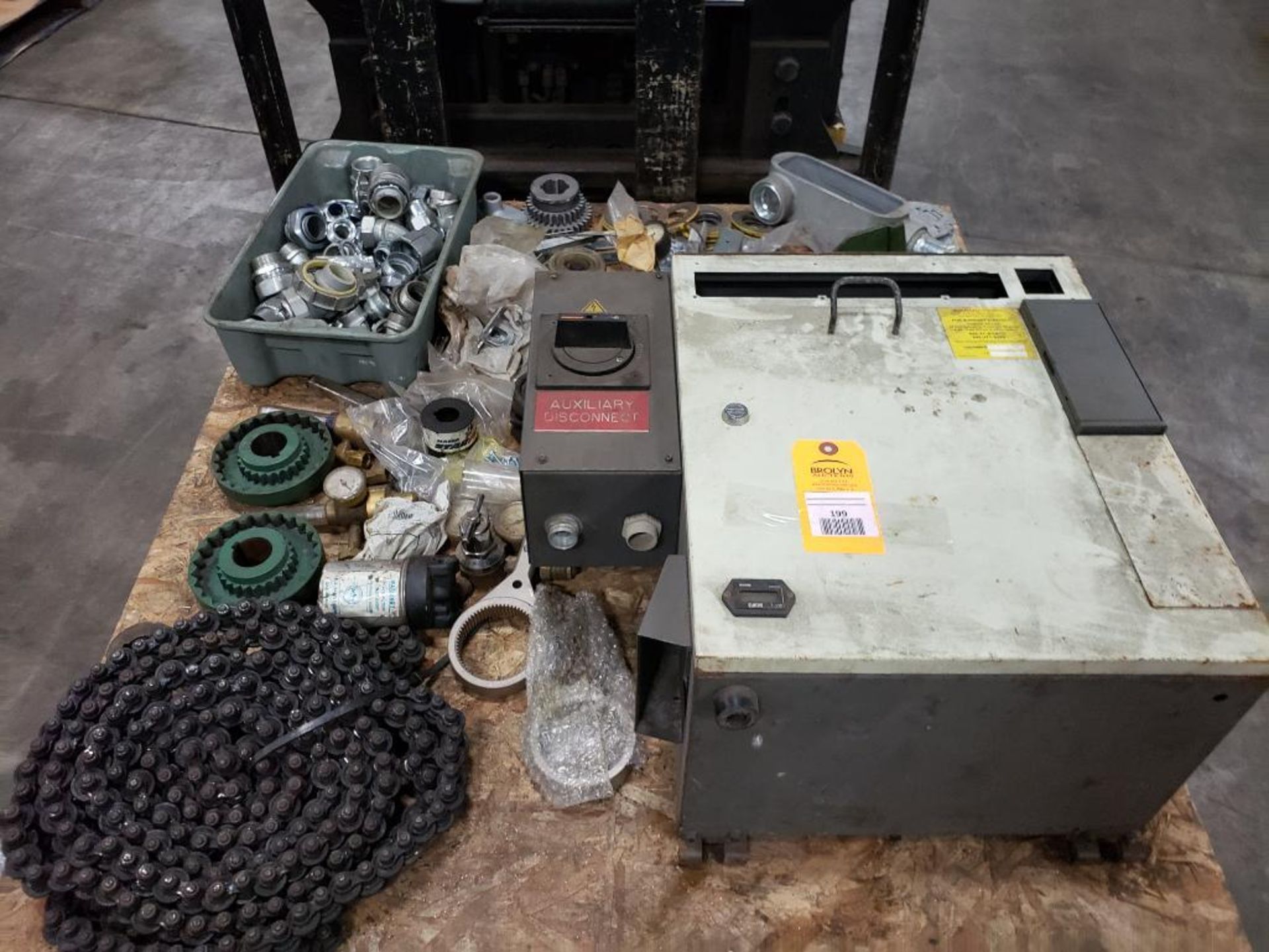 Pallet of assorted parts. Chain, gear, disconnect, pipe connections.