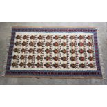 Tribal style Rug, Decorated with ten rows of five geometric motifs on an ivory ground, With a red