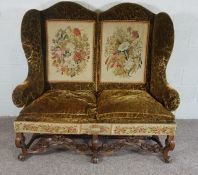 Walnut Framed Wing Back Settee, In Jacobean style, set with tapestry panels, on scroll legs and