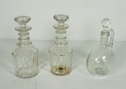 A pair of triple ring neck decanters and stoppers, 19th century, with paneled bodies, and a