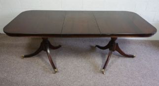 A George III style reproduction twin pedestal dining table, with turned pedestals and splay legs,