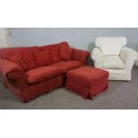 A three seater sofa and ottoman, currently upholstered in crimson, with a cream upholstered armchair