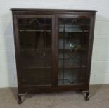 A George III style glazed stained pine bookcase, 20th century, with two doors enclosing shelves,