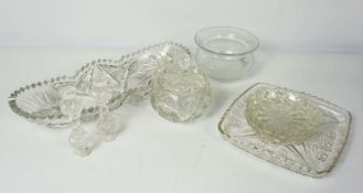 An assortment of glassware, including a pair of candlesticks, various drinking glasses, plates and