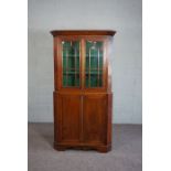 A George III provincial style mahogany corner cabinet, 19th century, with plain cornice over two