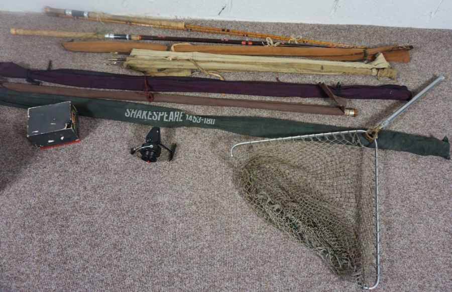 A group of fishing rods, a folding net, two reels and box of fishing magazines