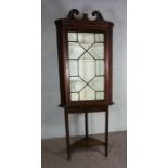 A George III style mahogany corner cabinet, 19th century, set on a later stand, with a swan necked