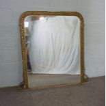 A Victorian composition gilt framed overmantel mirror, with a rounded rectangular plate and