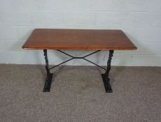 A cast iron and hardwood table, early 20th century, with a rounded rectangular top, on two leaf cast