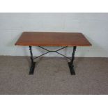 A cast iron and hardwood table, early 20th century, with a rounded rectangular top, on two leaf cast