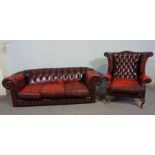 A Chesterfield three seat sofa, and similar armchair, both button upholstered in ox-blood '