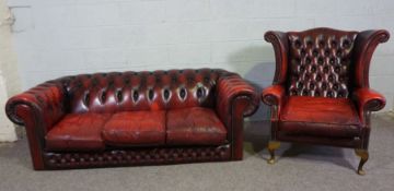 A Chesterfield three seat sofa, and similar armchair, both button upholstered in ox-blood '