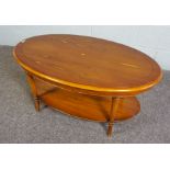 A modern Yew wood veneered two tier coffee table, the oval top set on four turned legs, 45cm high,