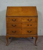 A George III style oak veneered bureau, 20th century reproduction, with three drawers and cabriole