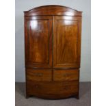 A George IV mahogany bowfront linen press, first half 19th century, with an arched cornice over