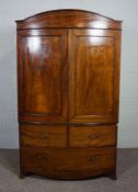 A George IV mahogany bowfront linen press, first half 19th century, with an arched cornice over
