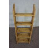 A modern stained pine open bookshelf, with five tiers