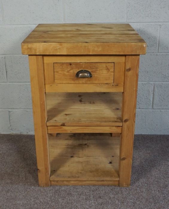 A provincial pine butchers block, 20th century, the thickly planked square top over a single knife