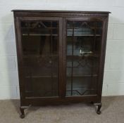 A George III style glazed stained pine bookcase, 20th century, with two doors enclosing shelves,