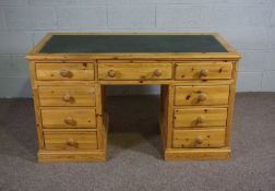 A modern varnished pine desk, with arrangement of nine drawers, late 20th century