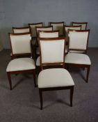 A set of ten 'mahogany' stained hardwood dining chairs, with cream cushioned backs and seats and