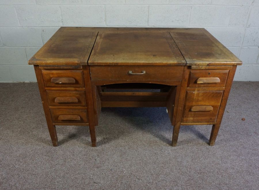 An oak typists desk, early 20th century, the rectangular top with folding and recessed typewriter