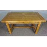 An oak refectory style extending dining table, contemporary, the rectangular planked top with two