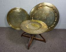 A Persian brass repousse tray, decorated with peacocks, 86cm diameter, together with a smaller