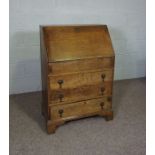 A small oak George III style bureau, with fall front and three drawers, 102cm high, 69cm wide