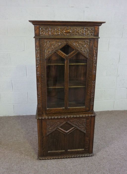 A small oak Jacobean style china cabinet, circa 1900, the top with a single glazed cabinet door,