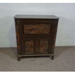 A 20th century hardwood chest, Chinese, with a rising top and cabinet doors, with integral carved