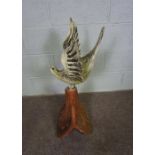 A decorative terracotta roof tile with bird surmount, the white painted bird with wings outspread,