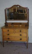 An oak dressing chest, circa 1900,  with arched mirror within pillar supports over three trinket