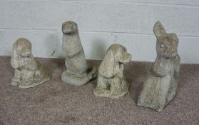 Four composition stone garden ornaments, including an otter, two spaniels and a faun  (4)