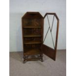A small oak Art Deco style glazed bookcase, with a single door and set on turned squat supports with