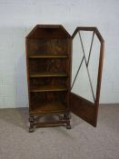 A small oak Art Deco style glazed bookcase, with a single door and set on turned squat supports with