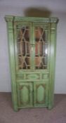 A George III style corner cabinet, 20th/21st century, with green painted decoration, fitted with two