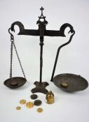 A wrought iron set of balance scales, 19th century, with nine assorted and graduated weights (10)