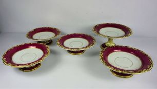 A Staffordshire part dessert service, decorated with scrolling gilt borders on a claret ground, with