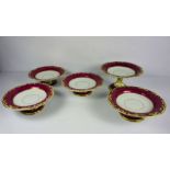 A Staffordshire part dessert service, decorated with scrolling gilt borders on a claret ground, with