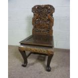 A Chinese carved hardwood side chair, 20th century, the back profusely carved with two dragons