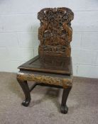 A Chinese carved hardwood side chair, 20th century, the back profusely carved with two dragons