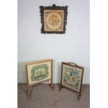 Two oak framed tapestry fire screens and an embroidered panel in an ornate fruit of the vine