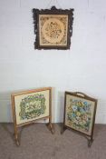 Two oak framed tapestry fire screens and an embroidered panel in an ornate fruit of the vine