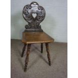 An oak hall chair, 18th/ 19th century, the carved back with scrolled decoration and pierced by a