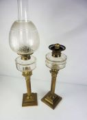Two Victorian brass column oil lamps, late 19th century, each with a clear glass reservoir, set on a