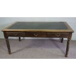 An oak library table, early 20th century, with rectangular leathered top, over three frieze