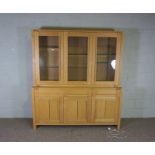 An ash wood dresser, contemporary, with three glass panelled doors opening to reveal glass