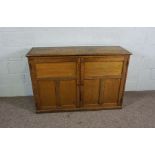 An oak side cabinet, circa 1900, with plain planked top and two panelled cabinet doors, 90cm high,