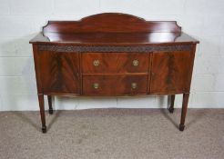 A George III style mahogany sideboard, 20th century, with two drawers and two cabinets on tapered